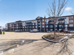 The property features a multi-story building with a brown, cream, and dark grey exterior, complete with balconies and numerous windows - 