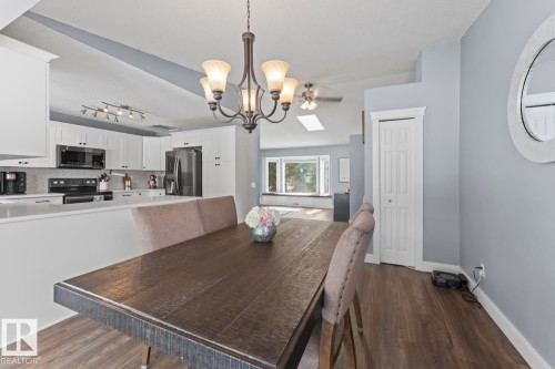 Open concept dining area featuring vinyl plank flooring, a chandelier - 1929 Forest Drive, Cold Lake, AB - Indoor Photo Showing Dining Room