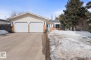 The property features a two-car garage with white doors, a paved driveway, and light-colored siding - 1929 Forest Drive, Cold Lake, AB  - Outdoor 