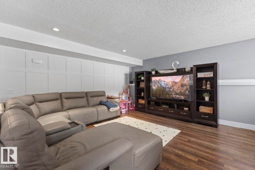 The living area features recessed lighting, wainscoting on one wall, and vinyl plank flooring - 1929 Forest Drive, Cold Lake, AB - Indoor Photo Showing Living Room