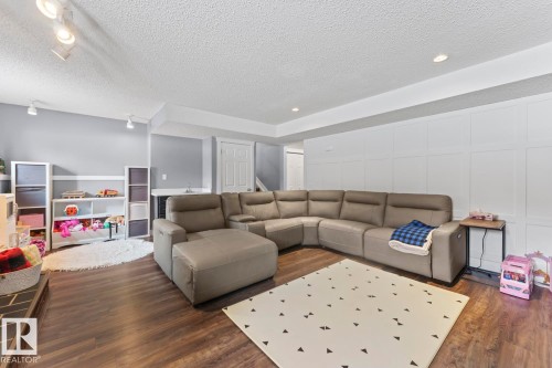 This versatile room features warm wood flooring, recessed lighting, and a white accent wall with panel detailing - 1929 Forest Drive, Cold Lake, AB - Indoor