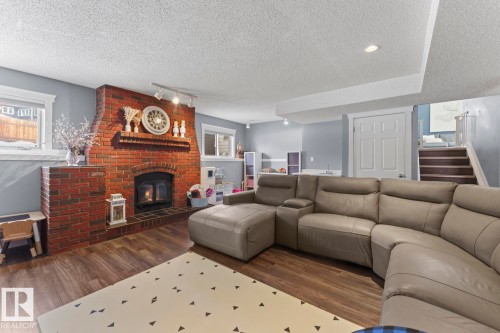 The living space features a brick fireplace with a mantel, recessed lighting, and vinyl plank flooring and wet bar. - 1929 Forest Drive, Cold Lake, AB - Indoor Photo Showing Living Room With Fireplace