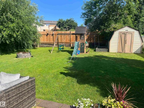 The property features a spacious backyard with a well-maintained lawn and a  privacy fence - 1929 Forest Drive, Cold Lake, AB - Outdoor With Backyard