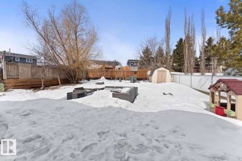 The property features an extensive backyard with a large patio, a storage shed, and a privacy fence - 1929 Forest Drive, Cold Lake, AB - Outdoor
