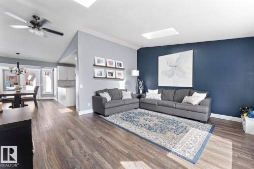 The open living area features vinyl plank flooring, a skylight, and a ceiling fan - 1929 Forest Drive, Cold Lake, AB - Indoor Photo Showing Living Room