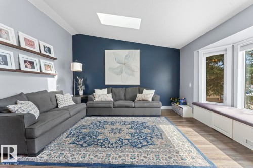 Spacious living area featuring a vaulted ceiling with a skylight, and a window seat with storage beneath - 1929 Forest Drive, Cold Lake, AB - Indoor Photo Showing Living Room