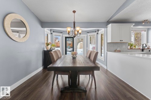 This dining area features vinyl plank flooring and an elegant chandelier - 1929 Forest Drive, Cold Lake, AB - Indoor Photo Showing Dining Room