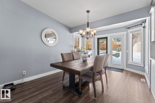 This dining area features large windows and a patio door, providing natural light - 1929 Forest Drive, Cold Lake, AB - Indoor Photo Showing Dining Room