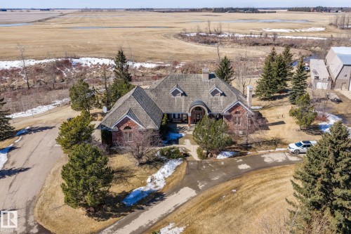 This property features a large house with a multi-gabled roof and brick exterior, set on a spacious lot with a paved driveway - 9610 167 Street Sw, Edmonton, AB - Outdoor With View