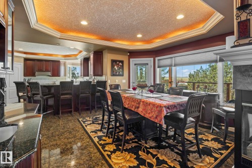 The property features an open concept kitchen and dining area with granite countertops, rich wood cabinetry, and recessed lighting - 9610 167 Street Sw, Edmonton, AB - Indoor Photo Showing Dining Room