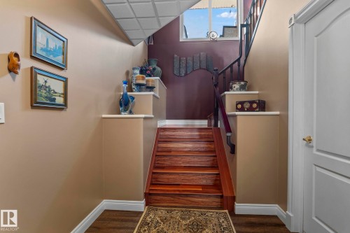 The property features a staircase with rich hardwood treads, a black metal railing, and a matching dark wood handrail - 9610 167 Street Sw, Edmonton, AB - Indoor Photo Showing Other Room