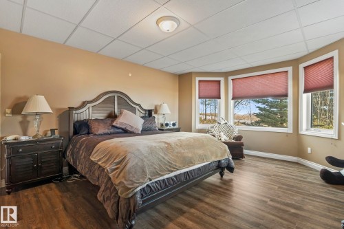 This room offers a warm ambiance with a neutral wall color and wood-look flooring - 9610 167 Street Sw, Edmonton, AB - Indoor Photo Showing Bedroom