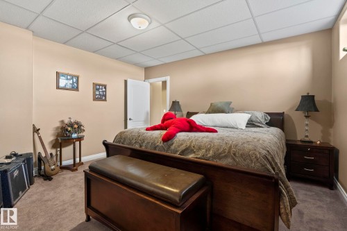 This room features a neutral color palette, carpeted flooring, and a drop ceiling with recessed lighting - 9610 167 Street Sw, Edmonton, AB - Indoor Photo Showing Bedroom