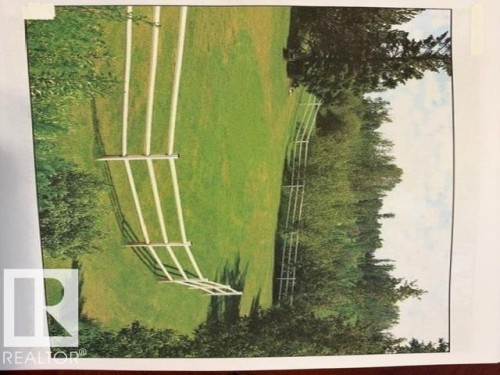 Expansive green lawn area, bordered by a white fence, and surrounded by mature trees - 9610 167 Street Sw, Edmonton, AB - 