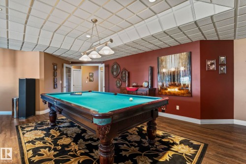 Recreation room featuring hardwood floors, a patterned area rug, a pool table with an overhead light fixture, and a decorative coffered ceiling - 9610 167 Street Sw, Edmonton, AB - Indoor Photo Showing Other Room