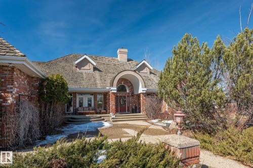 The property features a brick exterior with a unique shingle roof and dormer windows - 9610 167 Street Sw, Edmonton, AB - Outdoor