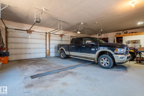 The property features a spacious garage with concrete flooring and overhead lighting - 9610 167 Street Sw, Edmonton, AB - Indoor Photo Showing Garage
