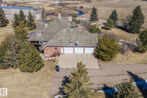 The property features a brick exterior, a large driveway, and a three-car garage - 9610 167 Street Sw, Edmonton, AB - Outdoor With View