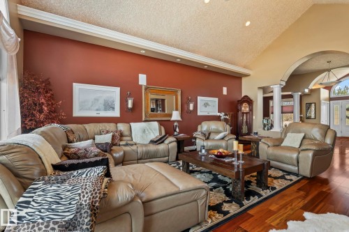 Living area featuring hardwood flooring, a vaulted ceiling, recessed lighting, and an arched entry - 9610 167 Street Sw, Edmonton, AB - Indoor Photo Showing Living Room