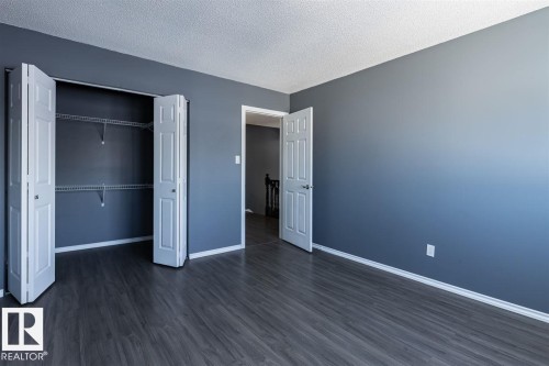 Room featuring dark grey walls, white trim, and dark wood-look flooring - 15204 94 Street, Edmonton, AB - Indoor Photo Showing Other Room
