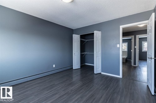 This room features dark gray walls, a textured white ceiling, and dark wood-style flooring - 15204 94 Street, Edmonton, AB - Indoor Photo Showing Other Room