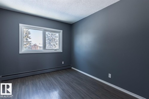 This room features contemporary gray walls and durable wood-look flooring - 15204 94 Street, Edmonton, AB - Indoor Photo Showing Other Room