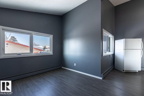 The interior features dark gray walls, white trim, and wood-look flooring - 15204 94 Street, Edmonton, AB - Indoor Photo Showing Other Room
