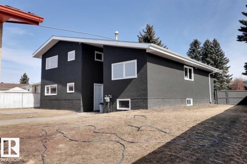 The property features a dark exterior finish with white window frames, offering a striking contrast - 15204 94 Street, Edmonton, AB - Outdoor With Exterior