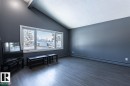 This spacious room features vaulted ceilings, large windows providing ample natural light, and modern flooring - 15204 94 Street, Edmonton, AB  - Indoor Photo Showing Other Room 
