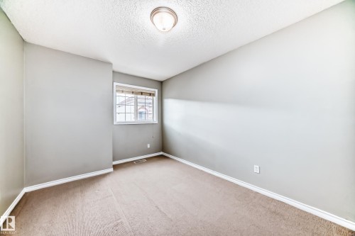 This room features a window providing natural light, light gray walls, and carpeted flooring - 105 13825 155 Avenue, Edmonton, AB - Indoor Photo Showing Other Room