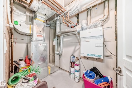 Utility room featuring exposed copper piping, a white "Tradewinds" unit, and various ductwork - 105 13825 155 Avenue, Edmonton, AB - Indoor Photo Showing Basement