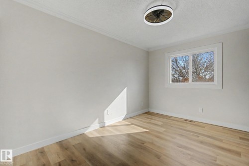 This room features light-colored flooring, white baseboards, and a window with a view of trees - 186 Centennial Crest, Edmonton, AB - Indoor Photo Showing Other Room