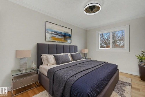 This bedroom features light wood flooring, a window providing natural light, and crown molding - 186 Centennial Crest, Edmonton, AB - Indoor Photo Showing Bedroom