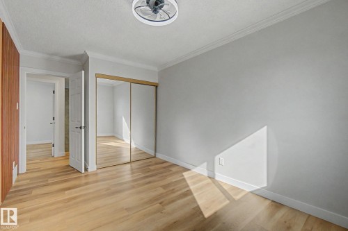 Room featuring light wood-style flooring, a ceiling fan, and mirrored closet doors - 186 Centennial Crest, Edmonton, AB - Indoor Photo Showing Other Room