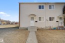 Exterior view of the property featuring light-colored siding, white-trimmed windows, a front door with an awning, and concrete steps leading to a paved walkway - 186 Centennial Crest, Edmonton, AB  - Outdoor With Exterior 