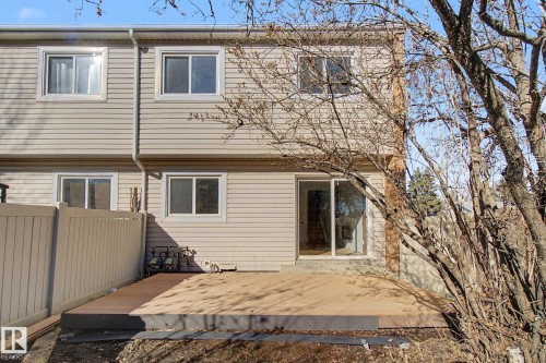 The property features a private fenced yard with a deck, sliding glass doors, and light-colored siding - 186 Centennial Crest, Edmonton, AB - Outdoor