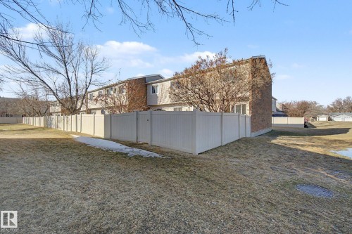 The property features a private backyard with a light-colored fence and a brick exterior - 186 Centennial Crest, Edmonton, AB - Outdoor