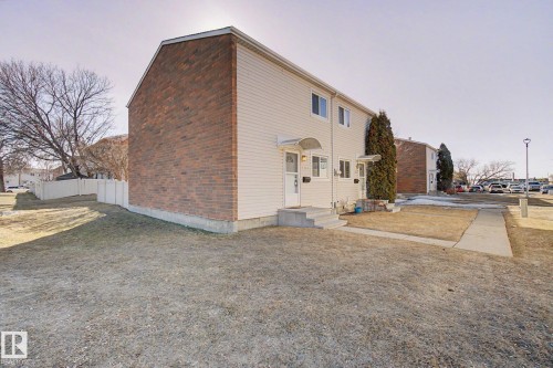 The property features a brick and siding exterior, a front yard with a concrete pathway, and a white fence along the property line - 186 Centennial Crest, Edmonton, AB - Outdoor