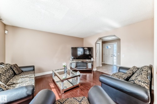 Spacious living area featuring hardwood flooring, light-colored walls, and a view towards the entrance - 11415 167A Avenue, Edmonton, AB - Indoor Photo Showing Living Room