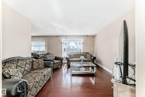 Living room featuring hardwood floors, light-colored walls, and a large window providing natural light - 11415 167A Avenue, Edmonton, AB - Indoor Photo Showing Living Room