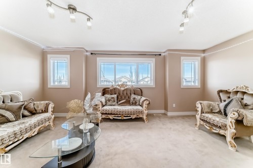 The living area features neutral-toned walls, windows providing natural light, and track lighting fixtures on the ceiling - 11415 167A Avenue, Edmonton, AB - Indoor Photo Showing Living Room