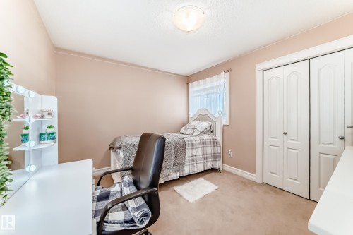 This room features a soft neutral wall color, carpeted flooring, and a window with sheer white curtains - 11415 167A Avenue, Edmonton, AB - Indoor Photo Showing Bedroom