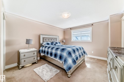 Spacious room with a window providing natural light, crown molding, and carpeted flooring - 11415 167A Avenue, Edmonton, AB - Indoor Photo Showing Bedroom