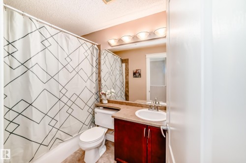 The bathroom features a vanity with a white sink, a mirror, and overhead lighting - 11415 167A Avenue, Edmonton, AB - Indoor Photo Showing Bathroom