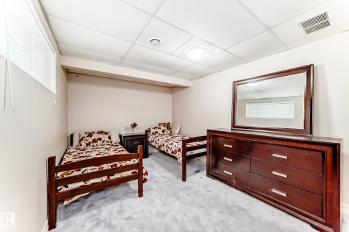 This inviting room features soft gray carpeting, light-colored walls, and a drop ceiling with recessed lighting - 11415 167A Avenue, Edmonton, AB - Indoor