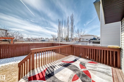 The property features an outdoor wooden deck with a railing and a private wooden fence - 11415 167A Avenue, Edmonton, AB - Outdoor