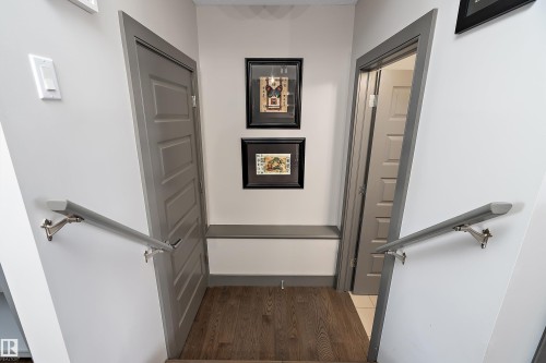 The interior hallway features hardwood flooring and light gray painted doors - 7776 Eifert Crescent Nw, Edmonton, AB - Indoor Photo Showing Other Room