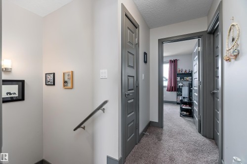 Upper level hallway featuring grey doors and trim, light grey walls, and a textured carpet - 7776 Eifert Crescent Nw, Edmonton, AB - Indoor Photo Showing Other Room