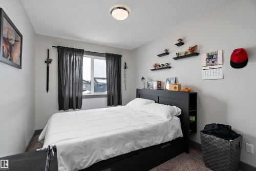 Bedroom featuring carpet flooring, a window with dark curtains, and a ceiling light fixture - 7776 Eifert Crescent Nw, Edmonton, AB - Indoor Photo Showing Bedroom
