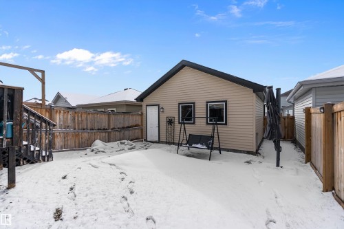 The property features a detached building with siding, a black roof, and exterior lighting - 7776 Eifert Crescent Nw, Edmonton, AB - Outdoor With Exterior